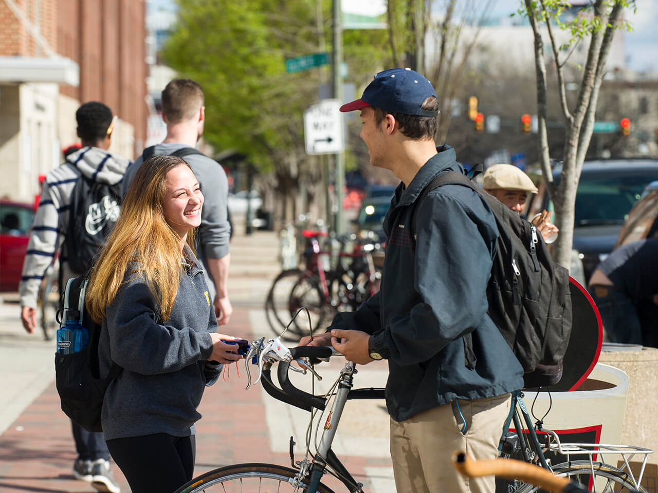 Two students having a conversation on the sidewalk