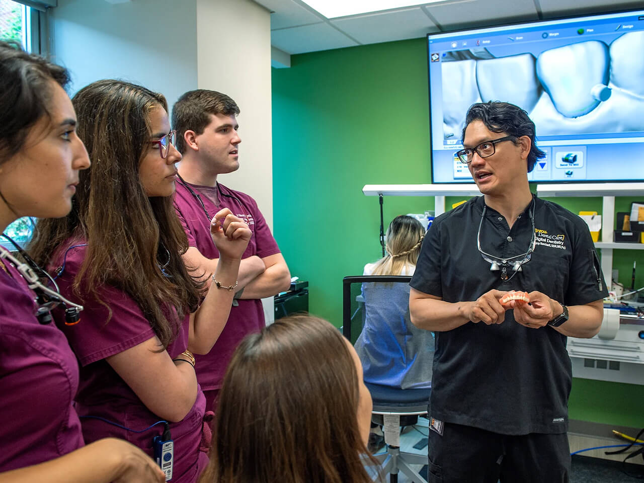 Teacher instructs students on how to scan and design custom fittings